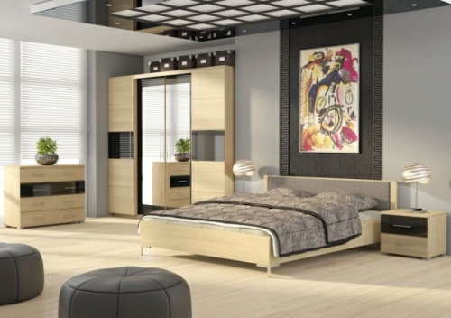 Příjemnou atmosféru této ložnice tvoří jednotný design skříně, komody, nočních stolků a postele. 